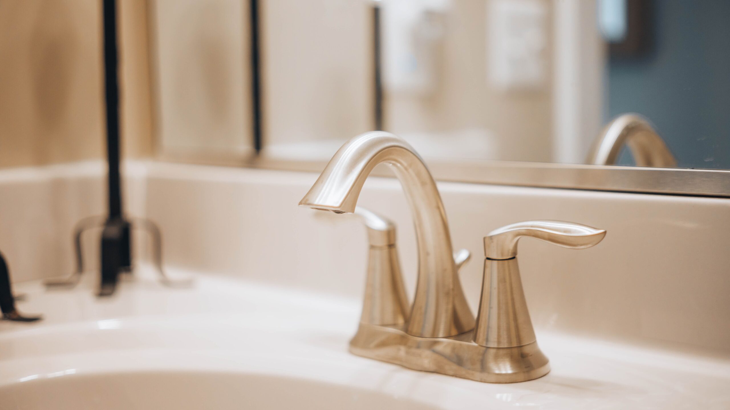 Close-up of a sleek modern bathroom faucet reflecting elegance and luxury.